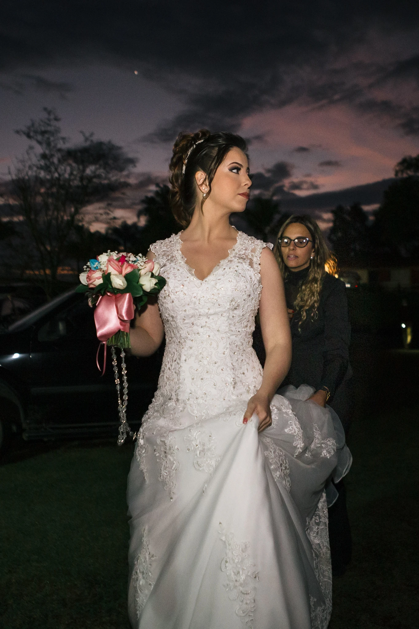A noiva ao entardecer, segurando a barra do vestido