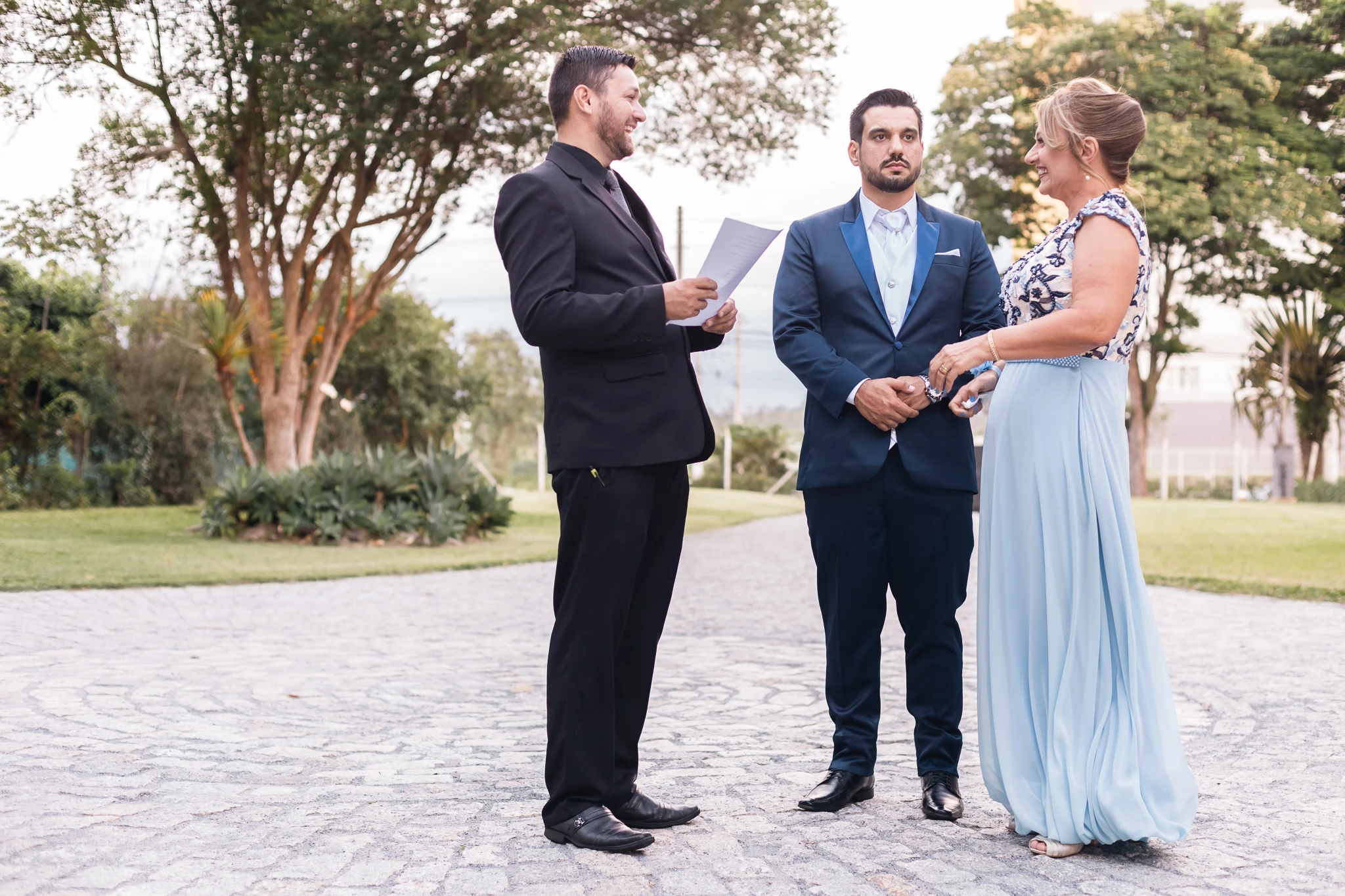 O noivo e a mãe conversando com o cerimonialista antes da entrada
